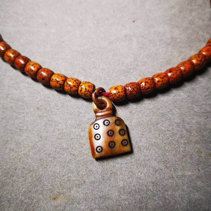 Yak Bone Carved Mantra Dot Prayer Bead Pendant - Tibetan Buddhist art, close-up detail
