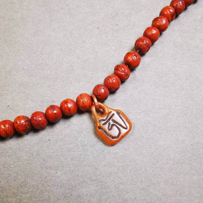 Yak Bone Carved OM Letter Prayer Bead Pendant - Tibetan Buddhist art, front view